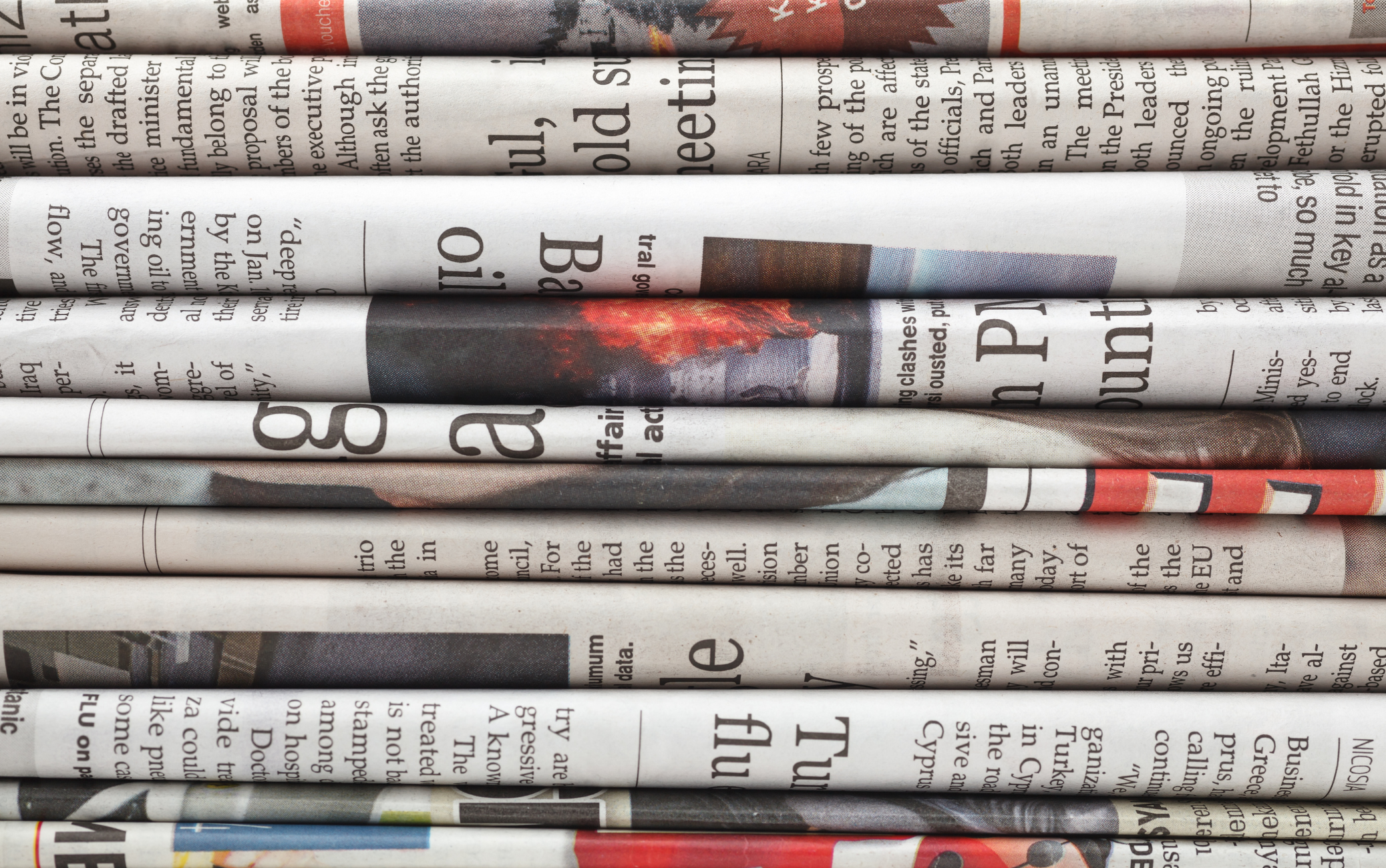 Pile de journaux vue côté tranche, pour symboliser la régularité des contenus éditoriaux, qui se construisent jour après jour