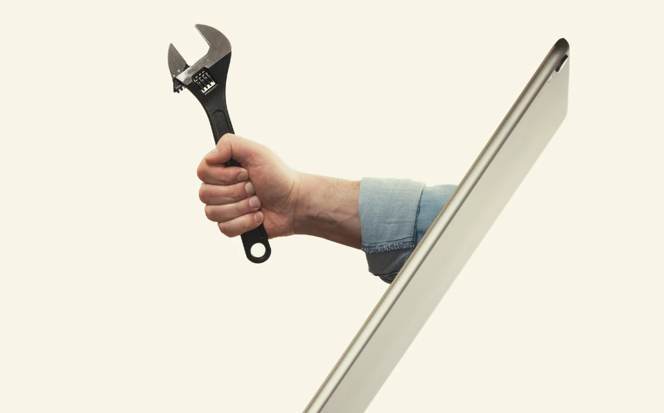 Main tenant une clé à molette, qui sort d'une tablette mobile, pour représenter le côté accessible d'un site carrières