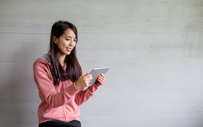 Jeune femme souriante, tenant une tablette numérique