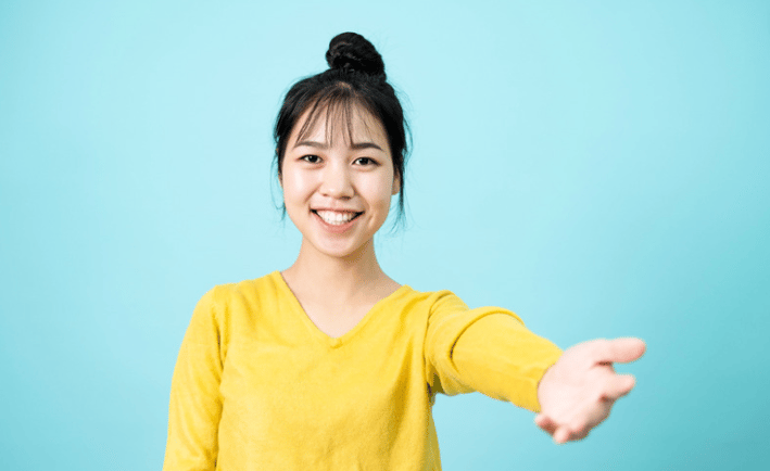 Jeune femme faisant un geste de la main qui invite à s'approcher