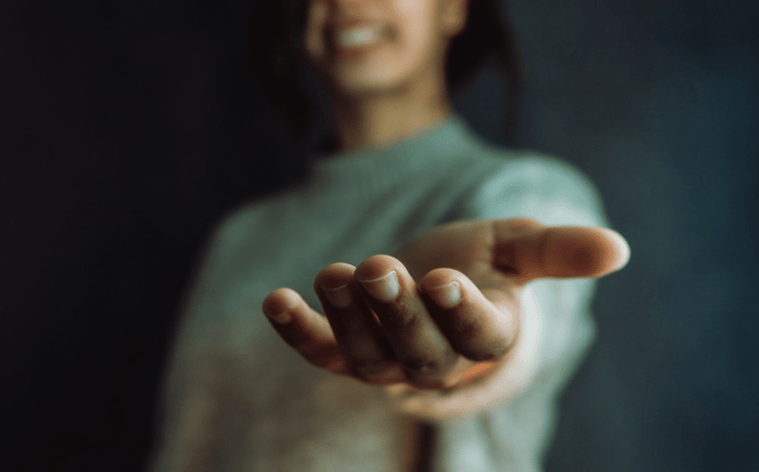 Responsable de mission handicap tendant la main devant l'objectif