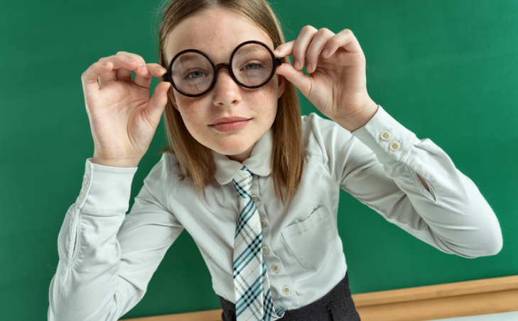 Petite fille habillée en tenu académique avec des lunettes rondes